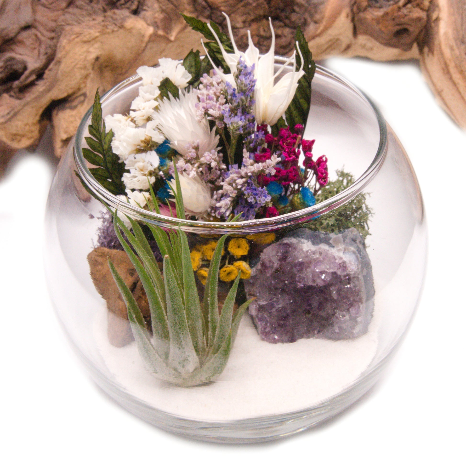 Airplant terrarium in a glass bowl with a bouquet of dried flowers, moss, wood and a raw amethyst crystal.